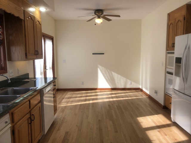 kitchen featuring ceiling fan, white appliances, sink, and light hardwood / wood-style flooring