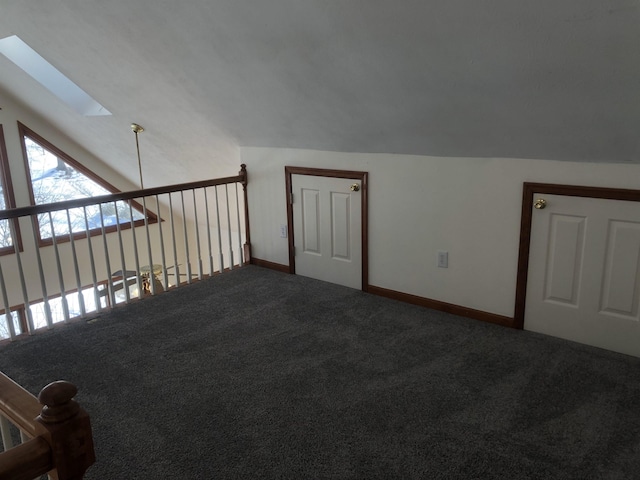 bonus room featuring vaulted ceiling with skylight and carpet