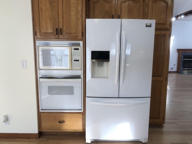 kitchen featuring hardwood / wood-style flooring and white refrigerator with ice dispenser