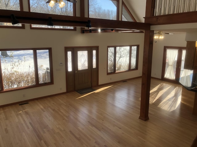 foyer with a high ceiling and wood-type flooring