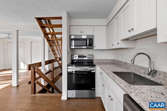 38 Firtree Dr, Wintergreen, VA 22967 - kitchen with a sink, a textured ceiling, dark wood-style flooring, decorative backsplash, and appliances with stainless steel finishes