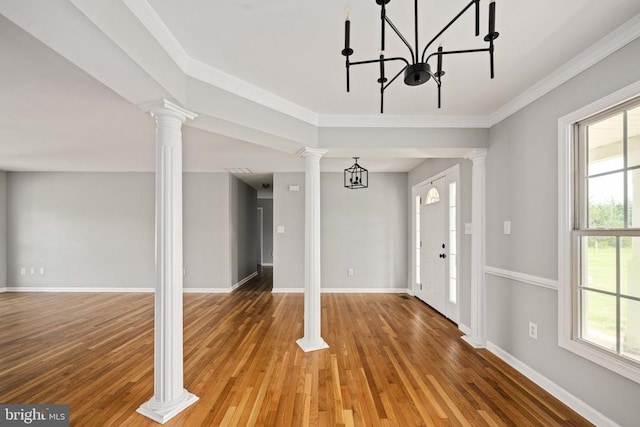  - foyer entrance featuring light wood-type flooring, decorative columns, baseboards, a chandelier, and crown molding