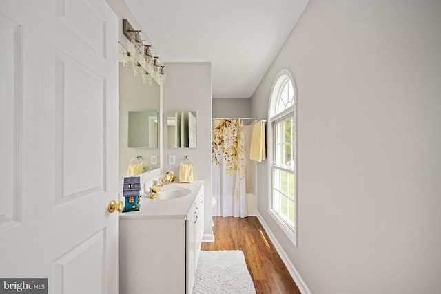 - bathroom with wood finished floors, a shower with curtain, vanity, and baseboards