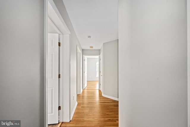  - corridor featuring light wood-style flooring and baseboards