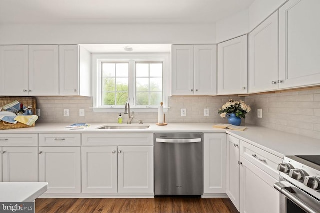  - kitchen with appliances with stainless steel finishes, a sink, white cabinets, and backsplash