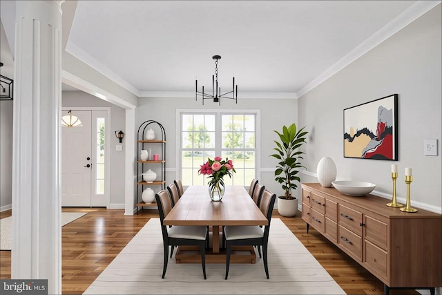  - dining area featuring a chandelier, dark wood-style flooring, crown molding, and baseboards