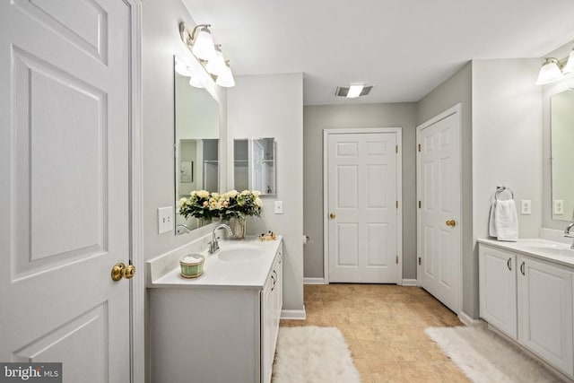  - bathroom featuring two vanities and baseboards