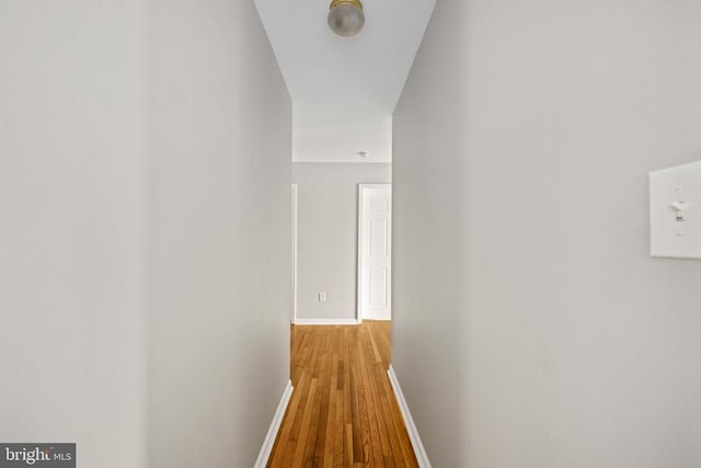  - hallway with baseboards and wood finished floors