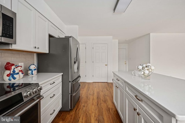  - kitchen featuring appliances with stainless steel finishes, light countertops, dark wood-style flooring, and white cabinets