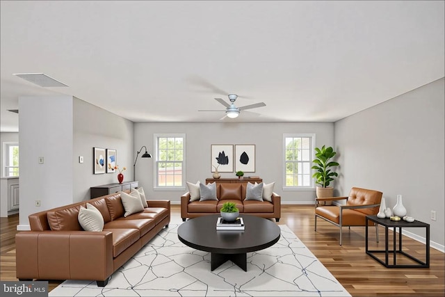 - living area featuring light wood-style flooring, a ceiling fan, and baseboards