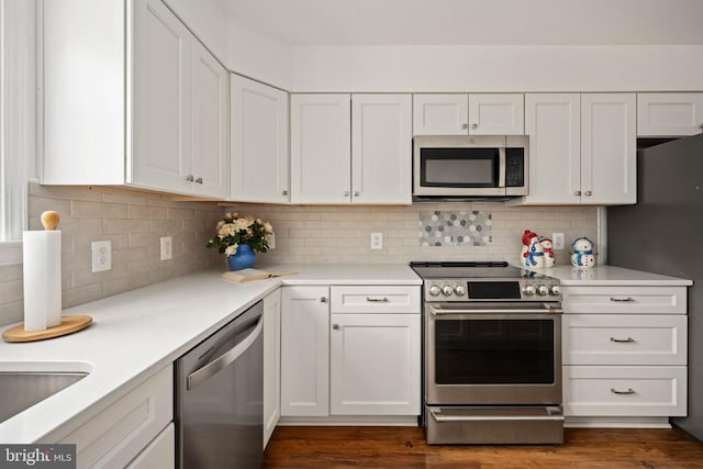  - kitchen featuring stainless steel appliances, white cabinets, light countertops, and backsplash