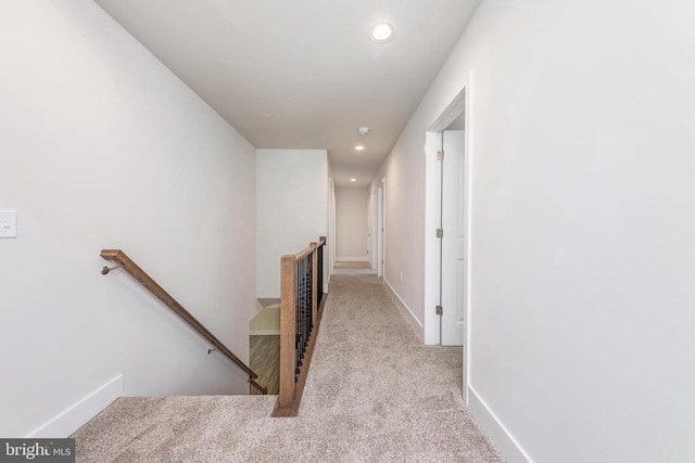 hall featuring an upstairs landing, carpet, recessed lighting, and baseboards