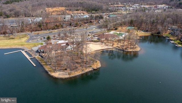 aerial view of property's location with a nearby body of water and a forest