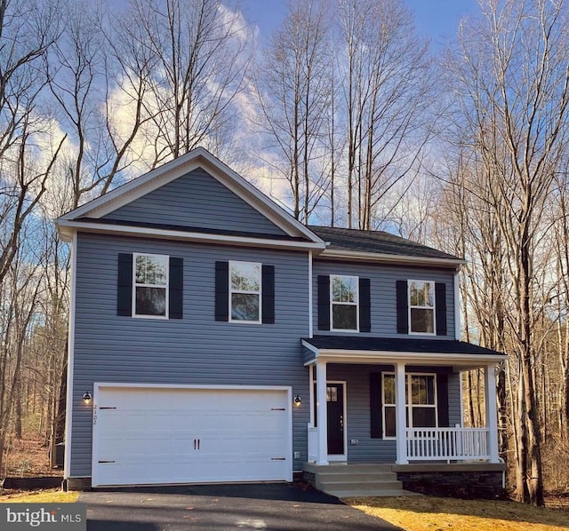 traditional home with a porch, an attached garage, and driveway