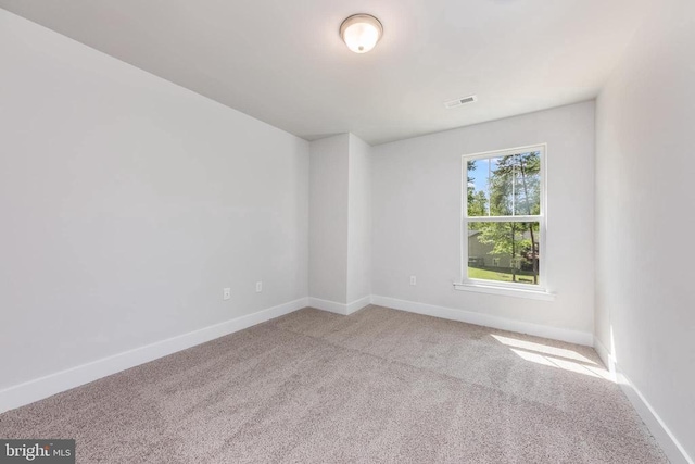 carpeted spare room featuring baseboards