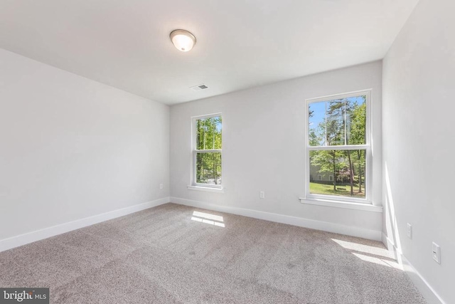 empty room featuring carpet and baseboards