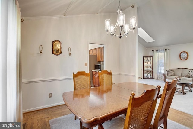 11911 Smoketree Blvd, Fredericksburg, VA 22407 - dining area with an inviting chandelier, baseboards, lofted ceiling with skylight, and crown molding