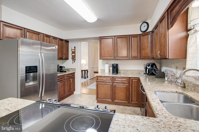 11911 Smoketree Blvd, Fredericksburg, VA 22407 - kitchen with a sink, stainless steel appliances, brown cabinetry, light stone countertops, and light tile patterned flooring