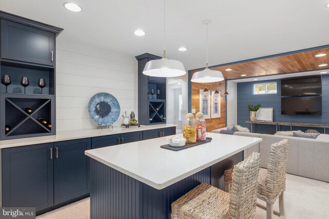 10501 Afton Grove Ct, Fredericksburg, VA 22408 - kitchen with wood walls, light countertops, a kitchen island, blue cabinets, and a breakfast bar