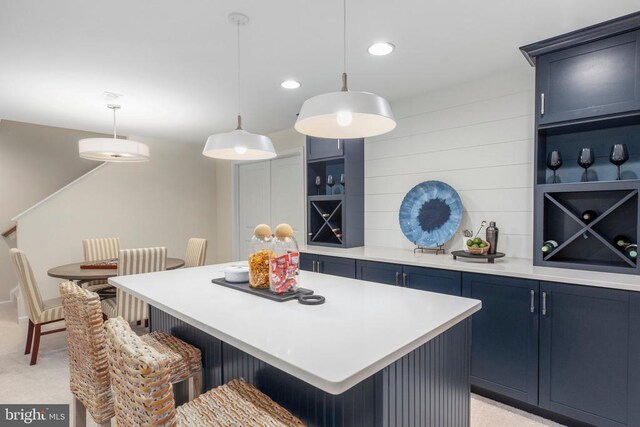 10501 Afton Grove Ct, Fredericksburg, VA 22408 - kitchen with blue cabinetry, a breakfast bar, light countertops, a kitchen island, and decorative light fixtures