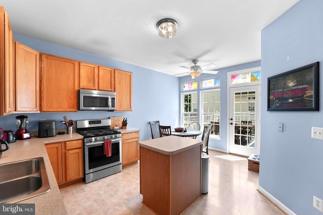 kitchen featuring stainless steel appliances, a sink, and light countertops