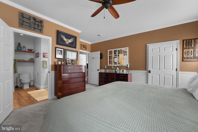 bedroom with ornamental molding, carpet flooring, a wainscoted wall, and connected bathroom