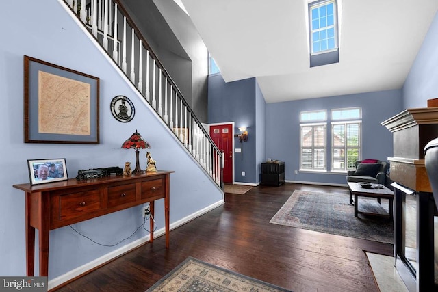 entryway featuring high vaulted ceiling, wood finished floors, stairway, and baseboards