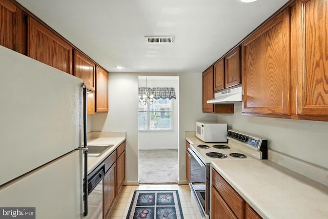 7637 Wankoma Dr, Remington, VA 22734 - kitchen featuring white appliances, under cabinet range hood, built in study area, light countertops, and brown cabinetry