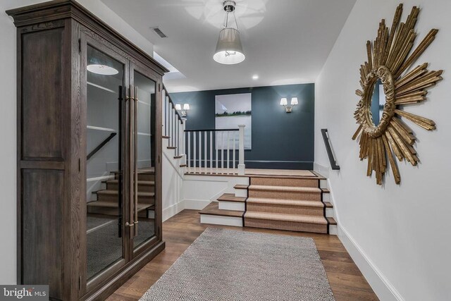 foyer with stairs, dark wood-style floors, and baseboards