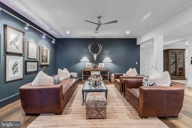 living area with a ceiling fan, wood finished floors, track lighting, recessed lighting, and baseboards