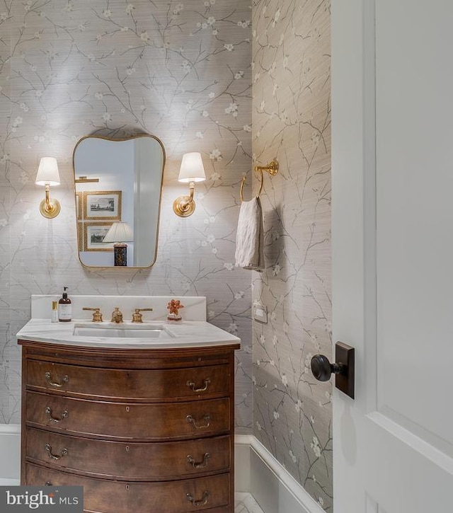 bathroom with vanity and wallpapered walls
