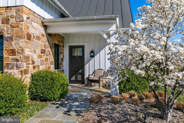 doorway to property with board and batten siding and stone siding