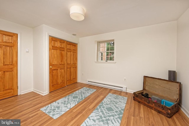  - sitting room featuring baseboard heating and wood finished floors