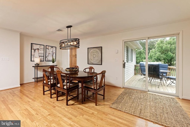  - dining area with light wood-style flooring, a chandelier, and crown molding