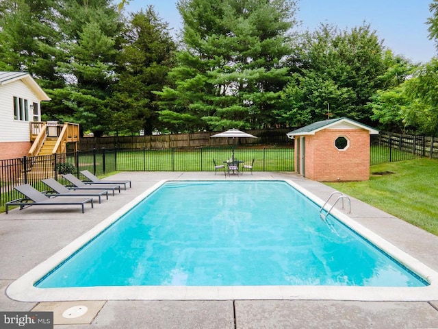  - view of swimming pool with a fenced backyard, view of scattered trees, a storage shed, and a patio