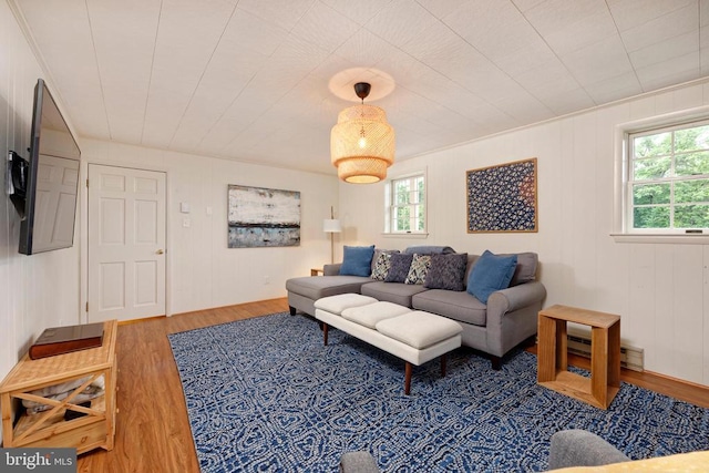  - living area with wood finished floors and a baseboard heating unit
