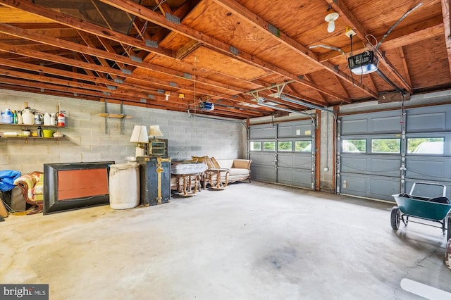  - garage featuring a garage door opener and concrete block wall