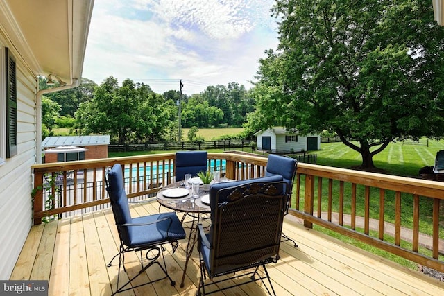 - wooden terrace featuring a storage unit and a fenced backyard