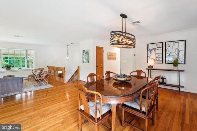  - dining space featuring light wood-type flooring, a chandelier, and ornamental molding