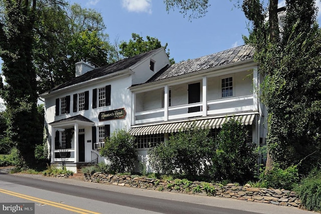  - view of front of home featuring stucco siding, cooling unit, and a chimney