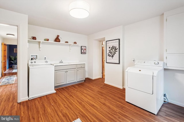  - washroom featuring cabinet space, light wood-type flooring, and washing machine and dryer
