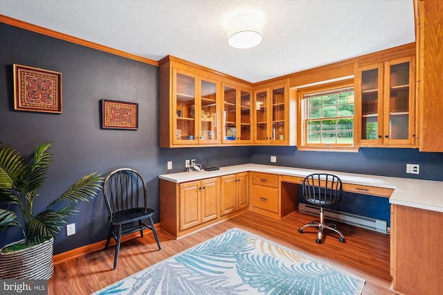  - office area with built in study area, a baseboard radiator, light wood-style floors, and ornamental molding