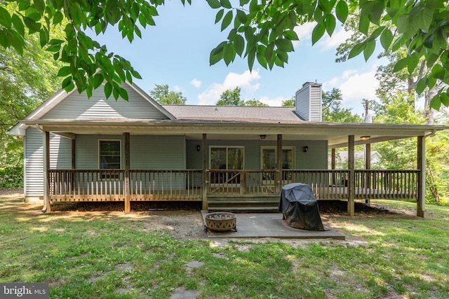 103 Patrick Henry Ct, Locust Grove, VA 22508 - rear view of house featuring a chimney, a lawn, a patio area, a fire pit, and a deck