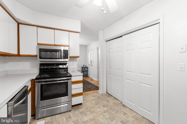 103 Patrick Henry Ct, Locust Grove, VA 22508 - kitchen featuring appliances with stainless steel finishes, white cabinets, light countertops, a ceiling fan, and stone finish flooring