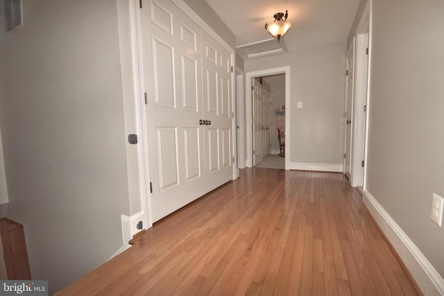  - hallway featuring light wood-type flooring, attic access, and baseboards