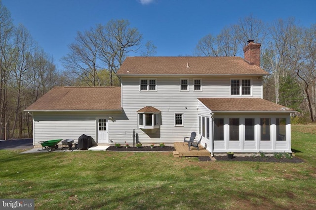  - back of property featuring a chimney, a lawn, and a shingled roof
