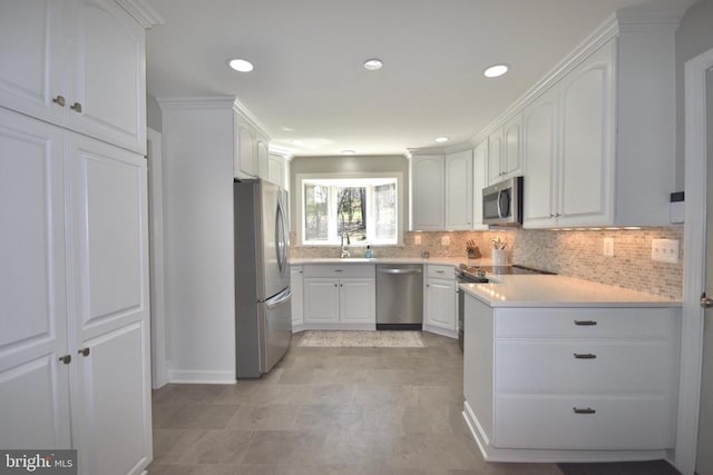  - kitchen featuring stainless steel appliances, a sink, white cabinetry, decorative backsplash, and light countertops