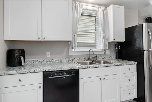238 Charlotte Ave N, Waynesboro, VA 22980 - kitchen featuring black dishwasher, a sink, freestanding refrigerator, and white cabinets