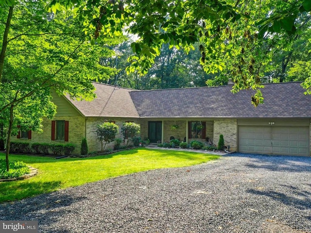  - single story home with brick siding, a garage, a front lawn, gravel driveway, and roof with shingles