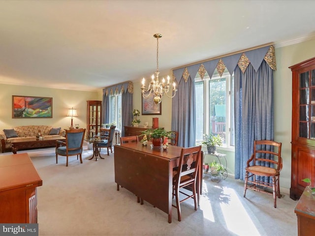  - dining area featuring light carpet, a chandelier, and ornamental molding